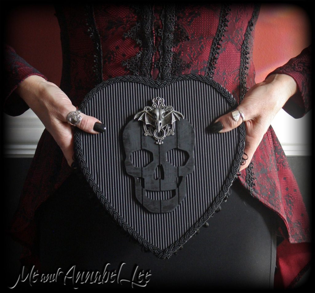 Gothic skull and raven gift box held by a woman's hands. 