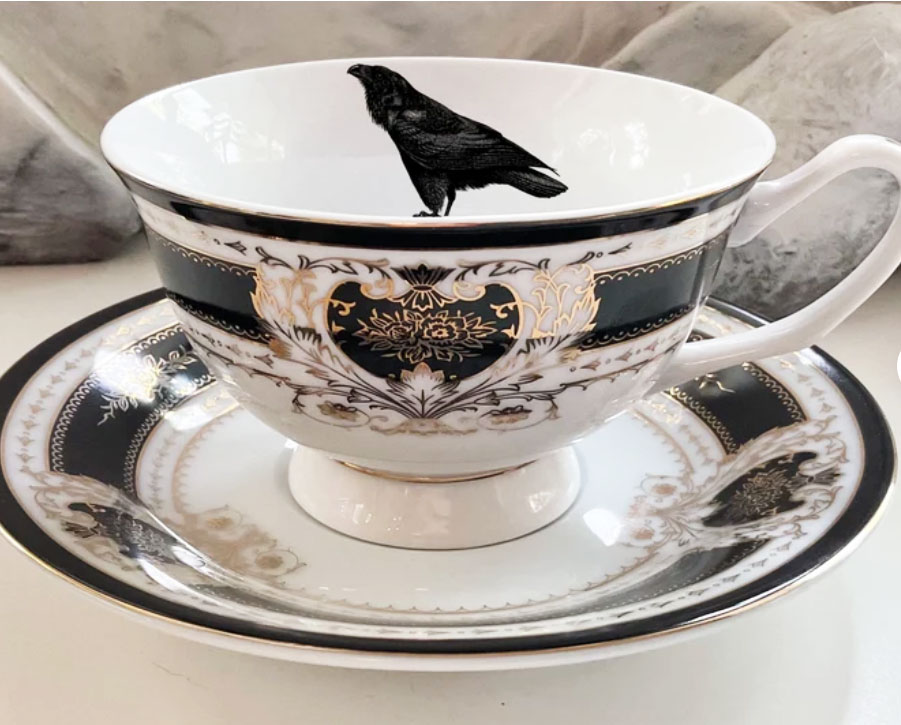 Black and white tea cup printed with a raven or crow on it. 