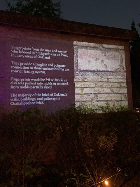 Information projected on to a cemetery's mausoleum. 
