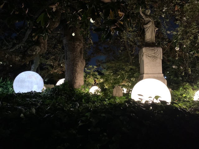Cemetery statutes lit by backlights. 