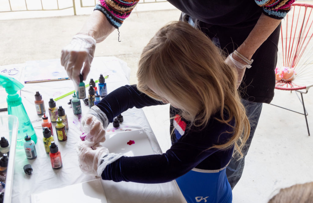 Little girl painting in a class. 