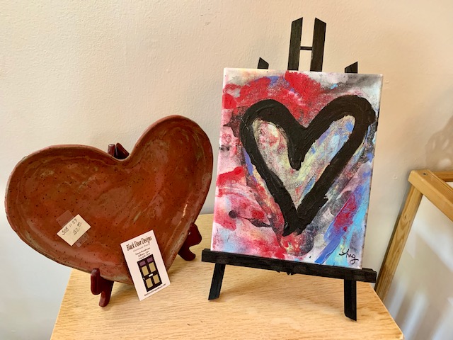 Heart shaped pottery next to a contemporary painting of a heart. 